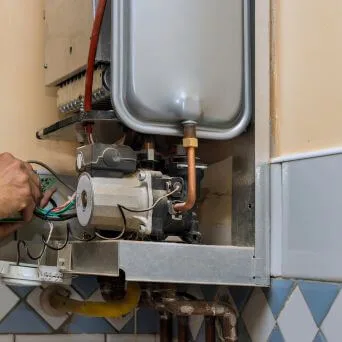 Close-up of a hot water unit’s valves and copper fittings